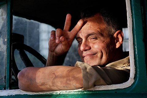 Smiling man giving a “V” sign in Havana, Cuba